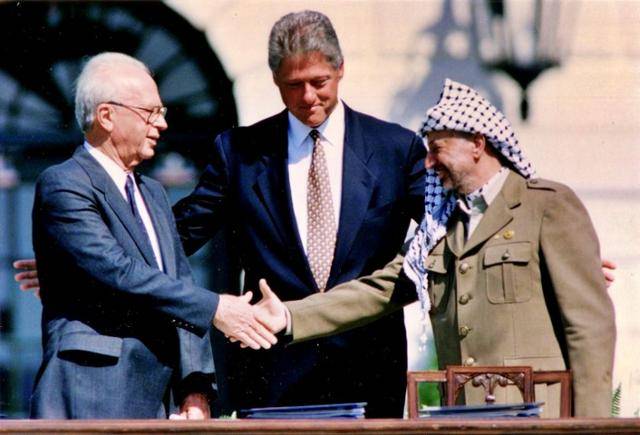 1993년 9월 13일 미국 워싱턴 백악관에서 빌 클린턴(가운데) 미국 대통령이 중재한 '오슬로 1차 협정' 서명을 마친 후 야세르 아라파트(오른쪽) 팔레스타인 해방기구(PLO) 의장이 이츠하크 라빈(왼쪽) 이스라엘 총리와 악수하고 있다. 이 협정의 서명은 백악관에서 이뤄졌으나 사전 협상이 주로 노르웨이 오슬로에서 이뤄져 '오슬로 협정'이라고 불린다. 워싱턴=로이터 연합뉴스
