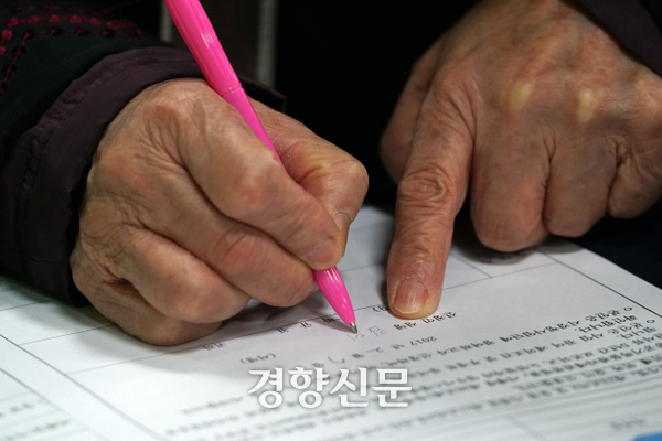 정부가 노후 소득 보장을 위해 퇴직연금을 단계적으로 의무화하기로 했다. 사진은 일자리 모집 행사에서 한 노인이 이력서를 작성하는 모습이다. 박민규 선임기자
