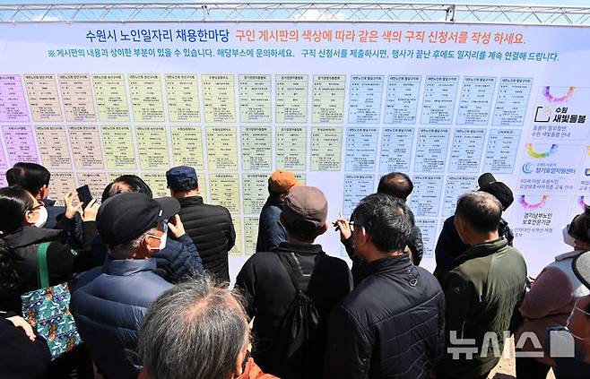 [수원=뉴시스] 김종택 기자 = 지난 3월 28일 경기도 수원시 팔달구 화성행궁 광장에서 열린 '노인일자리 채용한마당'을 찾은 어르신들이 채용정보 게시판을 살펴보고 있다. 2025.03.28. jtk@newsis.com