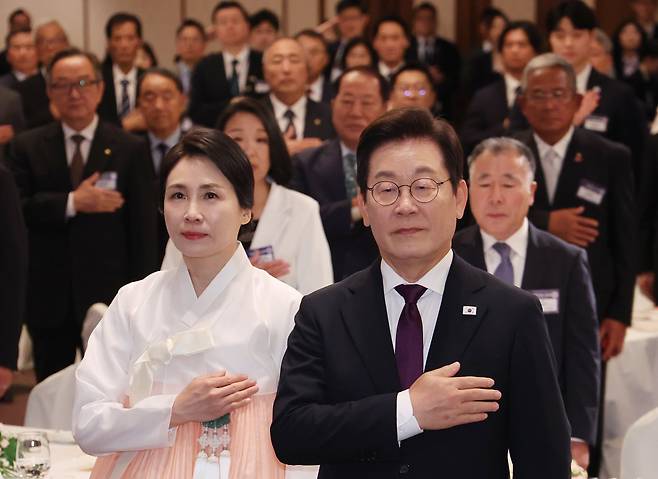 이재명 대통령과 김혜경 여사가 23일 일본 도쿄의 한 호텔에서 열린 재일동포 오찬 간담회에서 국기에 경례하고 있다. /연합뉴스