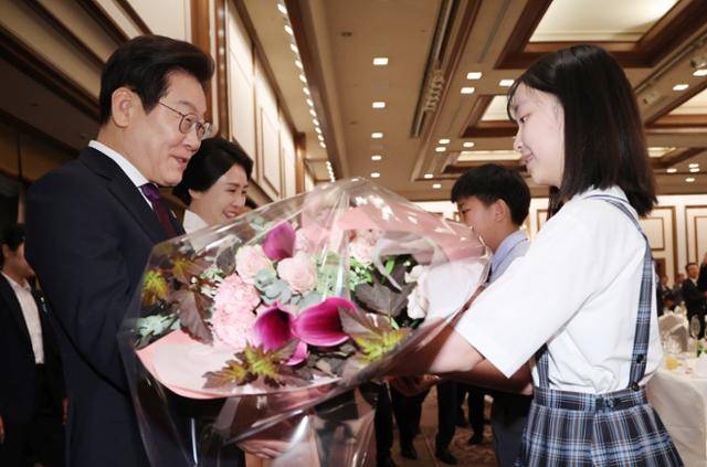 한일 정상회담을 위해 일본을 방문중인 이재명 대통령과 김혜경 여사가 23일 일본 도쿄의 한 호텔에서 열린 재일동포 오찬 간담회에서 화동에게 꽃다발을 받고 있다. 도쿄=뉴시스