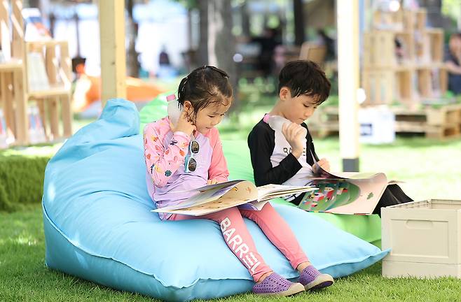 지난달 29일 대구 수성구 수성패밀리파크에서 어린이들이 책을 보며 더위를 식히고 있다. [연합]