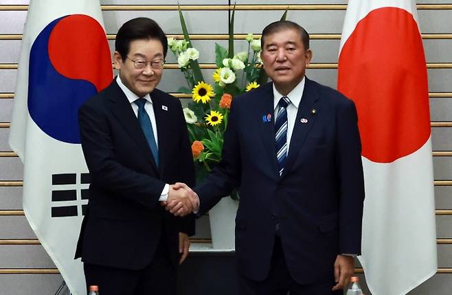 이재명 대통령과 이시바 시게루 일본 총리가 23일 일본 도쿄 총리 관저에서 열린 한일 확대정상회담에 앞서 기념 촬영을 하며 악수하고 있다. 도쿄 연합뉴스