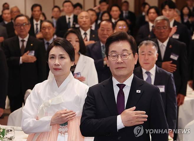 이재명 대통령 부부, 재일동포 간담회 참석 (도쿄=연합뉴스) 한상균 기자 = 이재명 대통령과 김혜경 여사가 23일 일본 도쿄의 한 호텔에서 열린 재일동포 오찬 간담회에서 국기에 경례하고 있다. 2025.8.23 xyz@yna.co.kr