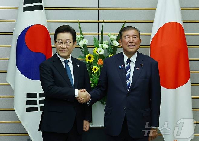이재명 대통령과 이시바 시게루 일본 총리가 23일 오후(현지시간) 일본 도쿄 총리 관저에서 열린 한일 확대정상회담에 앞서 악수를 하고 있다. ⓒ 로이터=뉴스1