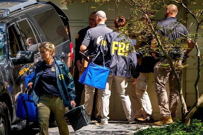 FBI 요원들이 2025년 8월 22일 메릴랜드주 베데스다에 있는 존 볼턴 전 대통령 국가 안보 보좌관의 집을 7시간 이상 수색한 후, 가방과 상자로 가득 찬 물품을 들고 출발하고 있다. /연합뉴스