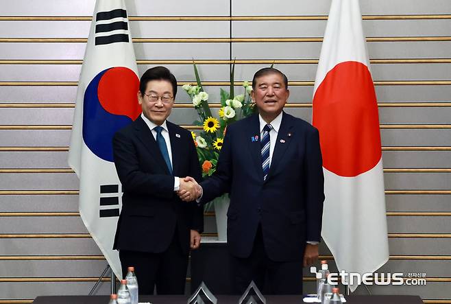 이재명 대통령과 이시바 시게루 일본 총리가 23일 일본 도쿄 총리 관저에서 열린 한일 확대정상회담에 앞서 기념촬영을 하며 악수하고 있다.  연합뉴스