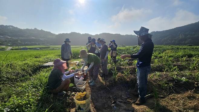 경남 산청에서 토사로 뒤덮인 생강밭 복구 작업 중 새참 시간. 자원봉사자들이 동네 카페 남다른이유에 기부자들이 복구 응원의 뜻으로 선결제해 둔 ‘까치밥’ 음료와 새참을 먹고 있다. 경남산청의료복지사회적협동조합 제공