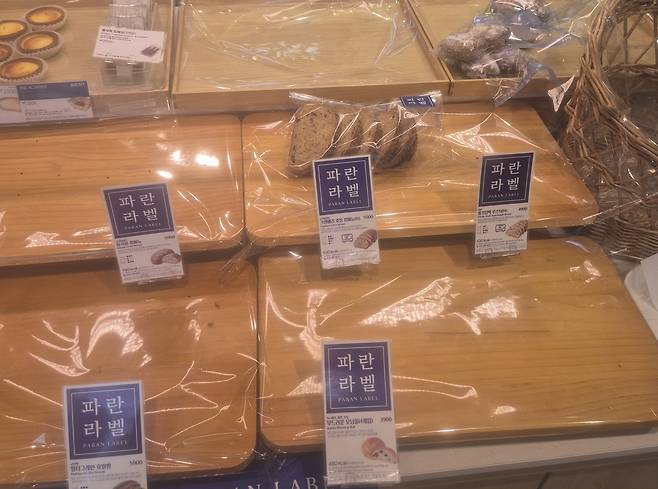 Shelves inside a Paris Baguette store in eastern Seoul on Aug. 20 stand empty as crowds of customers flock there for SK Telecom’s 50 percent discount event. [JOONGANG ILBO]
