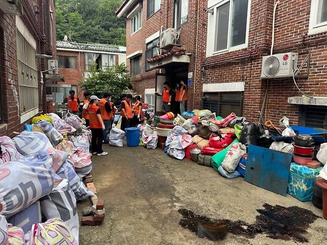 봉사자들이 공사 전 집 안에 있는 쓰레기를 치우는 모습. 빛과소금교회 제공