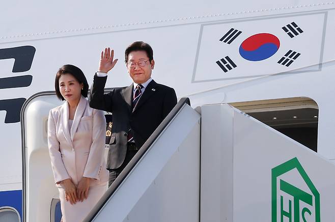 한일 정상회담을 마친 이재명 대통령과 부인 김혜경 여사가 24일 일본 도쿄 하네다공항에서 도널드 트럼프 미국 대통령과의 한미 정상회담을 위해 워싱턴DC로 향하며 공군1호기에 올라 인사하고 있다. [연합]