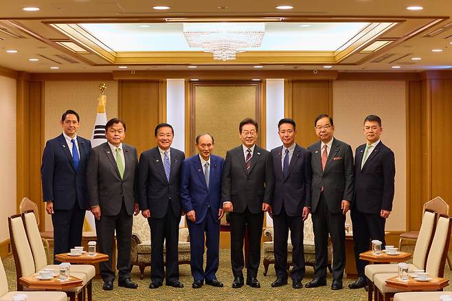 이재명 대통령이 24일 일본 도쿄의 한 호텔에서 일한의원연맹 회장인 스가 요시히데 전 일본 총리 등 일본 의원단을 접견하며 기념촬영을 하고 있다. [연합]