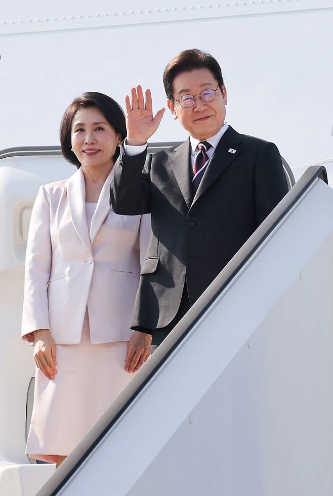 한일 정상회담을 마친 이재명 대통령과 부인 김혜경 여사가 24일 일본 도쿄 하네다공항에서 도널드 트럼프 미국 대통령과의 한미 정상회담을 위해 워싱턴DC로 향하며 공군1호기에 올라 인사하고 있다. [연합]