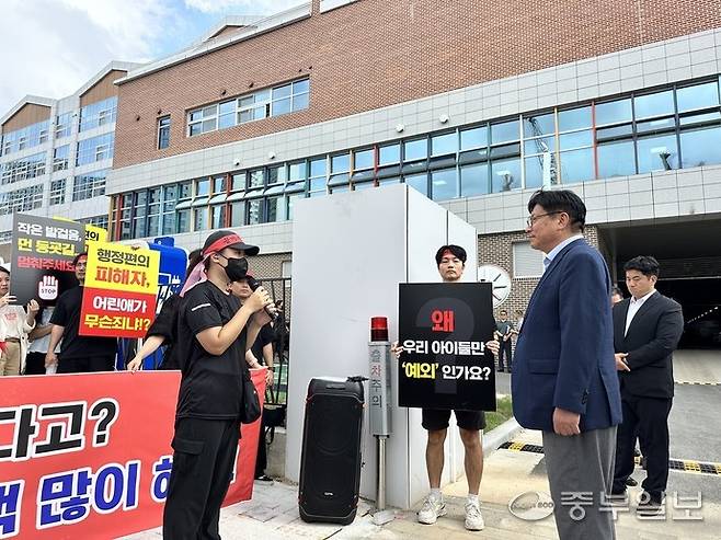 금강펜테리움입예협 관계자가 25일 오후 신검단초를 방문한 도성훈(오른쪽) 교육감에게 통학구역 변경에 대한 항의를 하고 있다. 사진=장수빈 기자