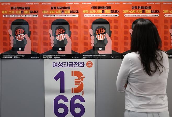 지난해 11월 서울 한국여성인권진흥원 디지털성범죄피해자지원센터에서 관계자가 딥페이크 예방 관련 포스터를 보고 있다. 연합뉴스
