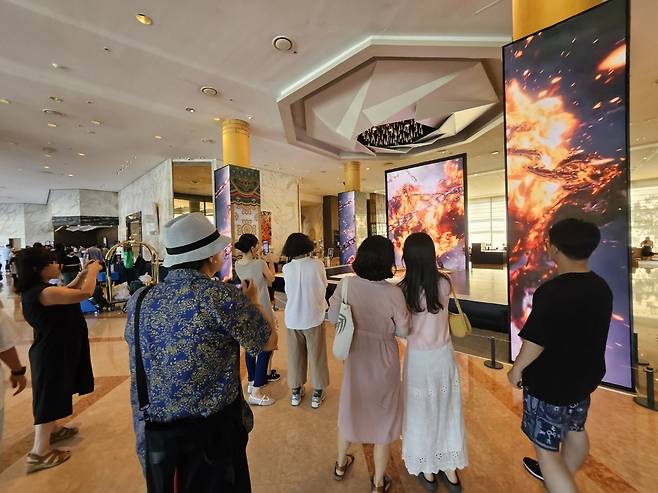 경북도가 마련한 특별전시 ‘빛으로 피어나는 신라’를 보기 위한 관람객들이 경주 힐튼호텔 중앙로비에서 작품의 사진을 찍으며, 연신 감탄하고 있다./경북도 제공