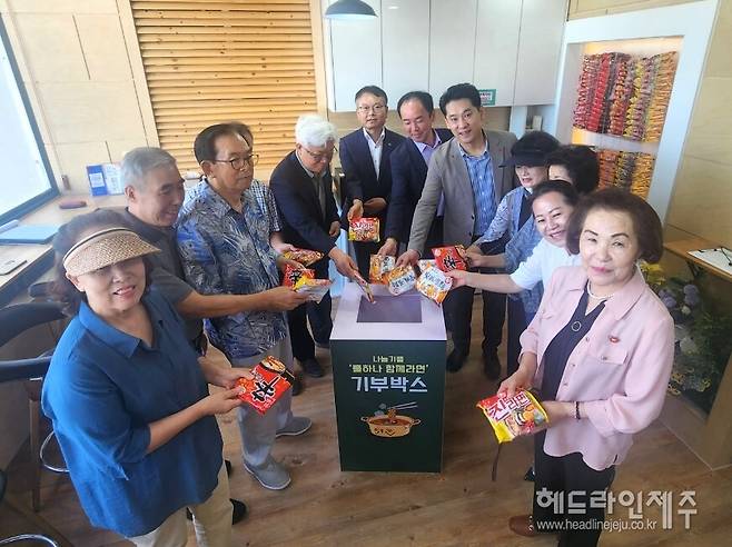 지난 20일 열린 제주시 이도1동의 '나눔기쁨, 둘하나 함께라면' 개소식 행사에서 참석자들이 라면을 기부함에 넣고 있다.