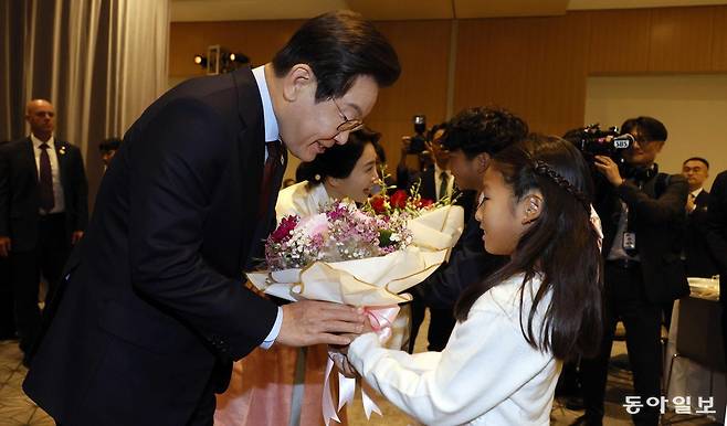이재명 대통령과 김혜경 여사가 24일(현지시간) 미국 워싱턴DC의 한 호텔에서 열린 재미동포 만찬 간담회에서 화동으로부터 꽃다발을 받고 있다. 2025.08.24. 송은석 기자 silverstone@donga.com