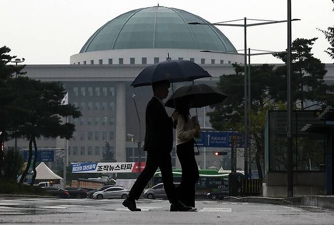 비가 내리는 가운데 우산을 쓴 시민들이 서울 여의도 국회 앞을 걸어가고 있다. 연합뉴스