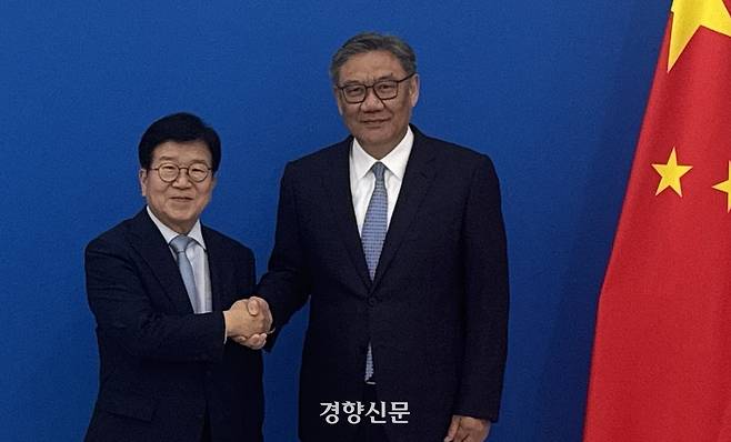 박병석 특사단장(왼쪽)과 왕원타오 중국 상무부장이 25일 상무부 청사에서 만나 손을 맞잡고 있다. 주중한국대사관 제공