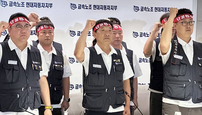 Union officials shout slogans during a press conference at the union's branch office in Hyundai Motor Group's Ulsan plant on Aug. 18. [NEWS1]