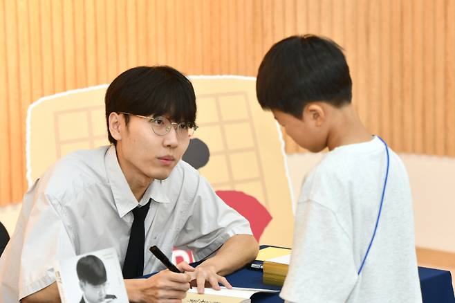 ‘바둑 황제’ 신진서 9단이 ‘레전드 오브 바둑’ 키즈 페스티벌에서 사인을 하고 있다. 한국기원 제공