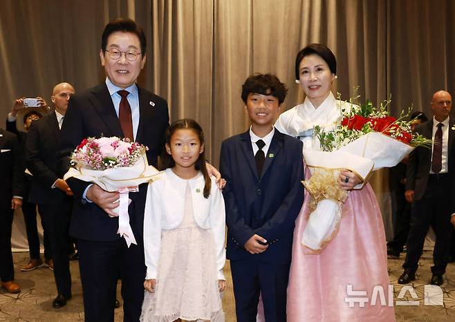 [워싱턴=뉴시스] 고범준 기자 = 이재명 대통령과 김혜경 여사가 24일(현지 시간) 미국 워싱턴DC의 한 호텔에서 열린 재미동포 만찬 간담회에서 화동과 기념촬영을 하고 있다. 2025.08.25. bjko@newsis.com