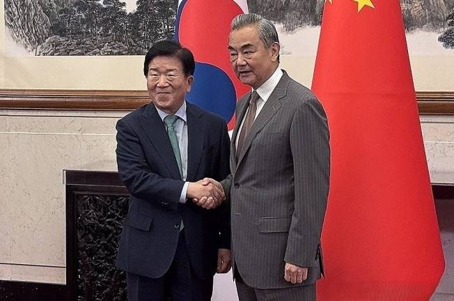 이재명 대통령 특사단장인 박병석 (왼쪽) 전 국회의장과 왕이 중국공산당 중앙외사판공실 주임 겸 외교부장이 지난 24일 베이징에서 만나 악수하고 있다. 베이징특파원 공동취재단