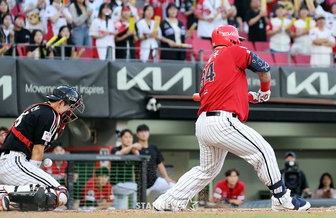 KIA 최형우(오른쪽)가 지난 22일 LG와 홈경기에서 체크 스윙을 하고 있다. 비디오 판독 결과 스윙에서 노 스윙으로 번복됐다.  /사진=강영조 선임기자