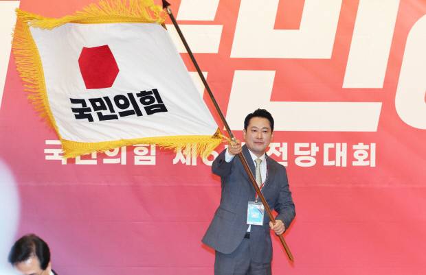 국민의힘 장동혁 신임 당 대표가 26일 서울 여의도 국회도서관에서 열린 제6차 전당대회 결선에서 당 대표로 선출된 뒤 당기를 흔들고 있다.  /연합뉴스