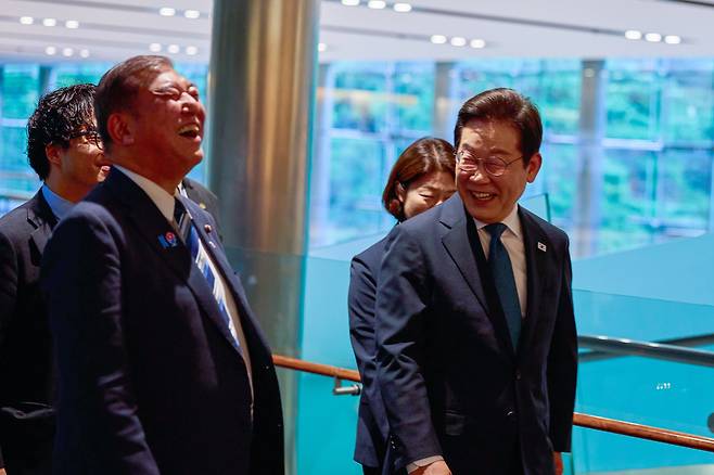 이재명 대통령이 한일 정상회담이 열린 지난 23일 일본 도쿄 총리 관저에 도착해 이시바 시게루 일본 총리와 대화하며 이동하고 있다./연합뉴스