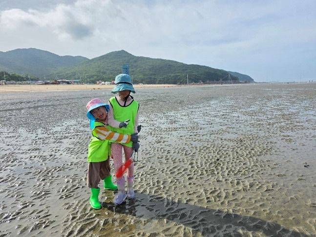 갯벌에서 누나를 꼭 껴안고 좋아하는 손자 ⓒ