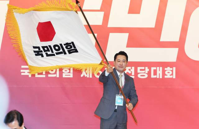 장동혁 국민의힘 신임 당 대표가 26일 여의도 국회도서관에서 열린 제6차 전당대회 결선에서 당대표로 선출된 뒤 당기를 흔들고 있다.