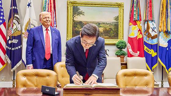 이재명 대통령이 25일(현지시간) 워싱턴DC 백악관에서 방명록을 작성하고 있다. 지켜보던 트럼프 대통령이 펜에 관심을 보이자 이 대통령이 즉석에서 선물했다. 김현동 기자