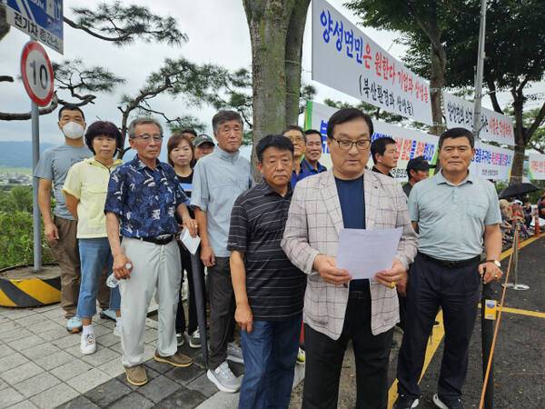 안성시 양성면 31개 마을 이장단협의회와 주민들이 26일 오전 안성시청 정문 앞에서 묵언 집회를 열고 의료폐기물 소각장사업 정당성을 주장하며 법과 원칙에 따라 주민들에게 실질적인 도움이 돼 달라고 호소하고 있다. 박석원기자
