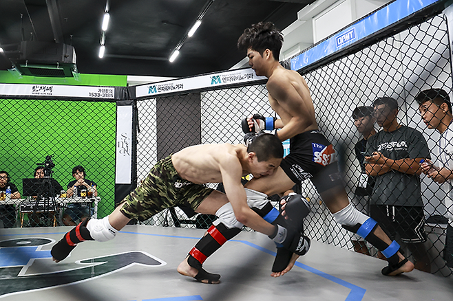 KMMA 플라이급 챔피언 문순수(왼쪽)가 도전자 김민기를 상대로 강력한 싱글레그 태클을 시도하고 있다. 사진=스탠다드앤드프로그레스 스포츠에이전시 제공