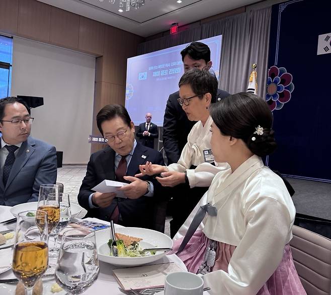 이재명 대통령이 지난 24일(현지 시간) 미국 워싱턴DC에서 열린 동포간담회에서 한 달여 전 공항에서 체포된 한국인 이민자에 대한 도움을 요청하는 서한을 전달받아 읽고 있다. ⓒ News1