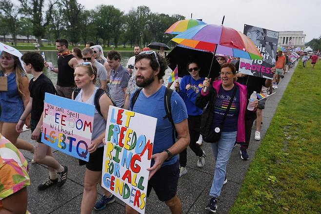 6월 8일(현지 시간) 미국 워싱턴 D.C. 링컨 기념관에서 열린 월드 프라이드 집회 참석자들이 손팻말을 들고 행진하고 있다. [워싱턴=AP/뉴시스]