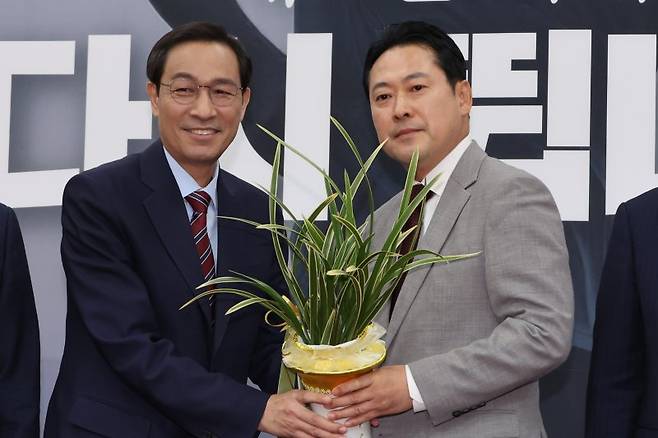 우상호 대통령실 정무수석이 27일 서울 여의도 국회에서 국민의힘 장동혁 신임 대표를 예방해 이재명 대통령이 보낸 축하난을 전달하고 있다. 연합뉴스