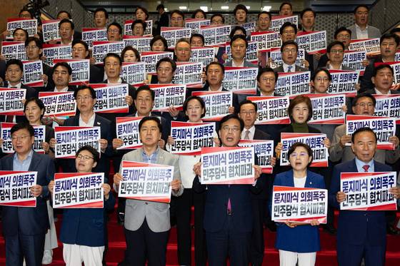 송언석 국민의힘 원내대표를 비롯한 의원들이 27일 서울 여의도 국회 로텐더홀에서 더불어민주당 협치파괴 규탄대회를 열고 구호를 외치고 있다. 뉴스1