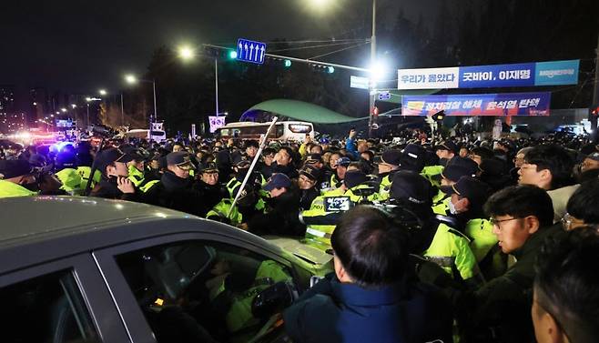 윤석열 대통령이 비상계엄을 선포한 가운데 2024년 12월4일 새벽 서울 여의도 국회 앞에서 군인이 탑승한 차량이 국회로 들어가려 하자 시민들이 막고 있다. 연합뉴스