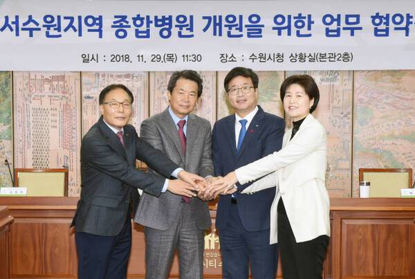염태영 당시 수원특례시장, 강병직 덕산의료재단 이사장, 이종옥 한국농어촌공사 당시 부사장, 민주당 백혜련 국회의원이 2018년 11월 시청에서 수원덕산병원 조성을 위한 업무협약을 체결하고 기념촬영을 하고 있다. 수원시 제공