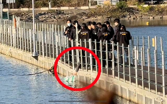 지난해 11월 6일 강원 화천군 북한강에서 함께 근무하던 여성 군무원을 살해한 뒤 시신을 훼손하고 북한강에 유기한 현역 군 장교 A(38)씨에 대한 현장 검증이 진행되고 있다. 사진은 A씨가 다리 위에서 훼손된 시신이 담긴 봉투를 강 아래로 떨어뜨리는 범행 당시 상황을 재연하는 모습.  연합뉴스