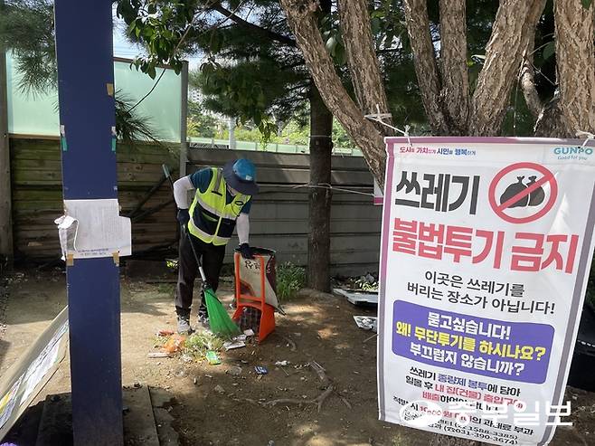 지난 26일 체감온도 40도에 육박하는 무더위 속에서 군포시 환경공무직 근로자가 당정역 1번 출구 인근에 남겨진 쓰레기를 치우고 있다. 손용현 기자