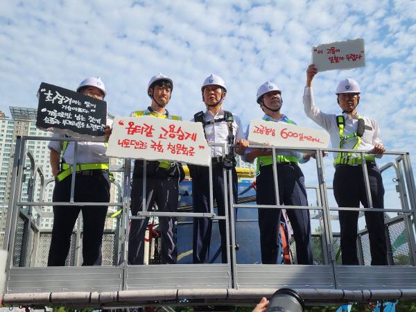 정청래 더불어민주당 대표(사진 중앙)가 28일 구미소재 한국옵티칼하이테크 고공농성현장을 방문, 고공농성 중인 박정혜 한국옵티칼하이테크지회 수석부회장을 만나기 위해 고소크레인을 타고 올라가고 있다.사진제공 더불어민주당 경북도당