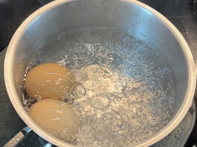 물이 끓고 있는 냄비 안에 든 계란 2개