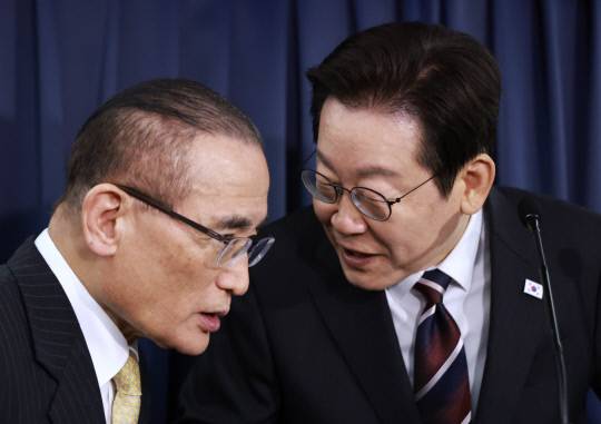 이재명 대통령과 위성락 국가안보실장이 24일(현지시간) 일본 도쿄 하네다공항 이륙 뒤 한미 정상회담을 위해 미국 워싱턴DC로 향하는 공군 1호기 기내에서 기자간담회를 하며 논의하고 있다. 연합뉴스