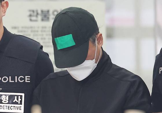 부모와 처자식 등 일가족 5명을 살해한 50대 가장 이씨가 경기도 용인동부경찰서 유치장에서 검찰로 송치되는 모습. 연합뉴스