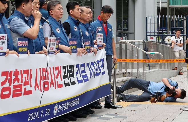 지난해 7월29일 오전 서울 중구 경찰청 앞에서 열린 경찰관 사망사건 관련 긴급 기자회견을 취재 중인 도준석 기자. 사진 앵글에 경찰청 깃발을 넣기 위해 옆으로 누워 찍었다. /도준석 제공