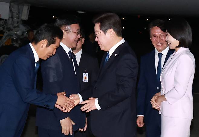 이재명 대통령과 김혜경 여사가 일본·미국 방문 일정을 마치고 28일 경기도 성남 서울공항에 도착해 더불어민주당 정청래 대표와 인사하고 있다. <연합뉴스>
